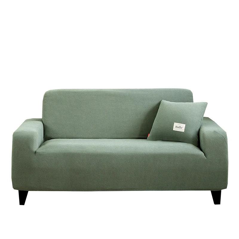 Housse de canapé Cléa en coton extensible, moderne et durable verte.